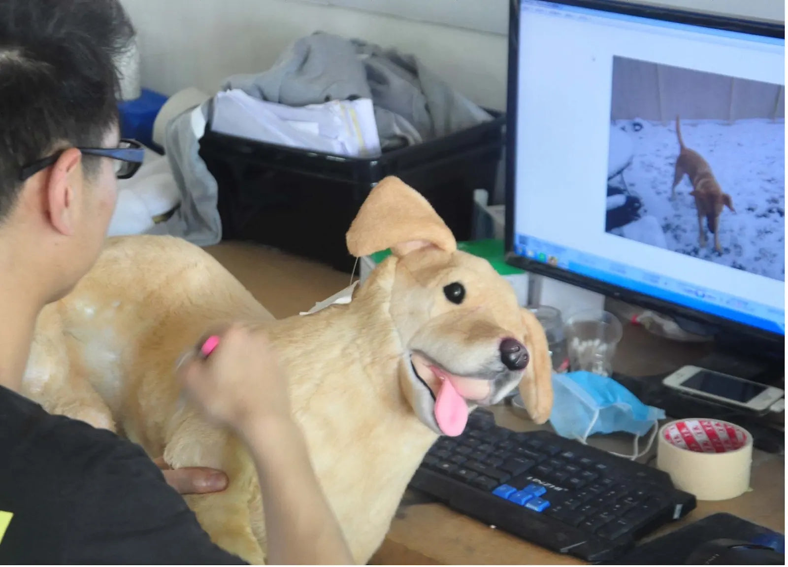 DragonMoss artist comparing a handmade dog plush with the customer’s pet photo